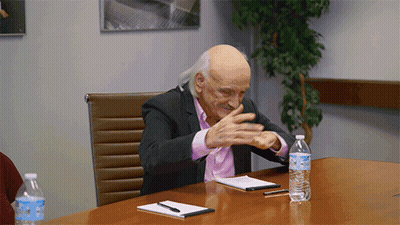 A Man Sitting At A Table With A Bottle Of Aquafina Water On It GIF