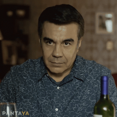 A Man Sitting At A Table With A Bottle Of Wine And A Glass With Pantaya Written On The Bottom Right GIF