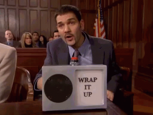 A Man Sitting At A Table With A Box That Says Wrap It Up On It GIF
