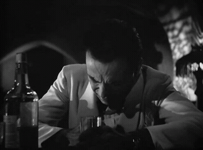 A Man Sitting At A Table With A Glass Of Gin And The Words Of All The Gin Joints GIF