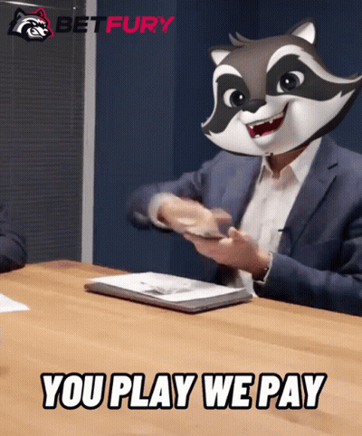 A Man Sitting At A Table With A Raccoon Mask On His Head And The Words You Play We Pay Below Him GIF