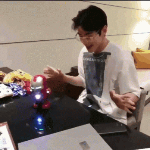 A Man Sitting At A Table With A Shirt That Says Oepream 18 2007 On It GIF