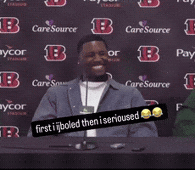 A Man Sitting At A Table With A Sign That Says " First I Boiled Then I Serious " GIF