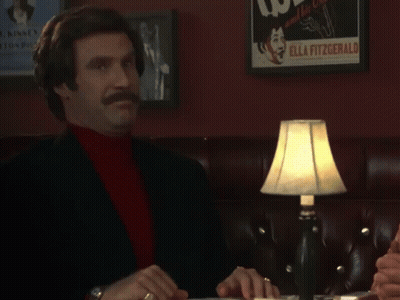 A Man Sitting At A Table With A Sign That Says Thank You Sir Or Madame GIF