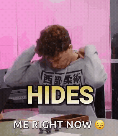 A Man Sitting At A Table With His Hands On His Head And The Words Hides Me Right Now GIF