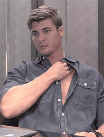 A Man Sitting At A Table With His Shirt Open GIF