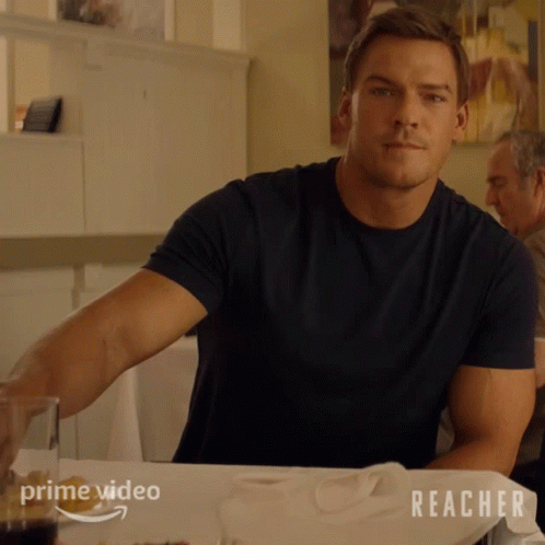 A Man Sitting At A Table With Reacher On The Table GIF