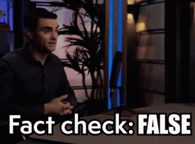 A Man Sitting At A Table With The Words " Fact Check False " Written On It GIF