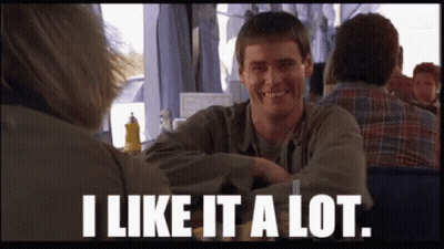 A Man Sitting At A Table With The Words " I Like It A Lot " Below Him GIF