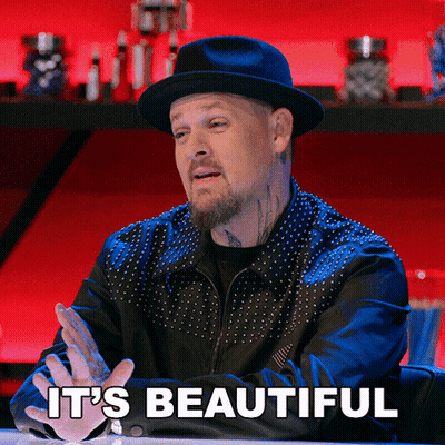 A Man Sitting At A Table With The Words It 'S Beautiful Above Him GIF