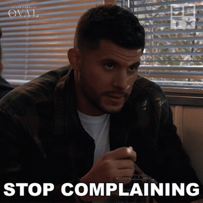 A Man Sitting At A Table With The Words Stop Complaining On The Bottom Right GIF
