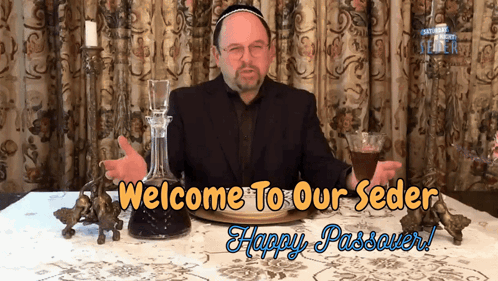 A Man Sitting At A Table With The Words Welcome To Our Seder Happy Passover On The Bottom GIF