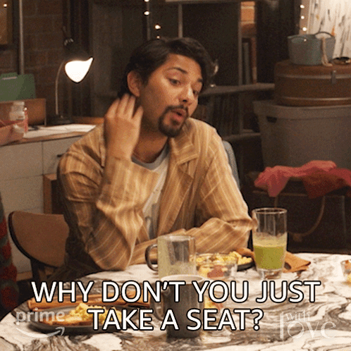 A Man Sitting At A Table With The Words Why Don 'T You Just Take A Seat GIF