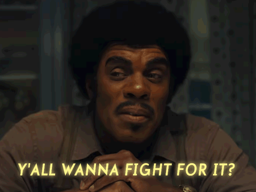 A Man Sitting At A Table With The Words Y'all Wanna Fight For It GIF