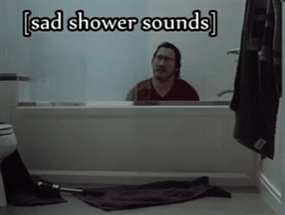 A Man Sitting In A Bathtub With The Words Sad Shower Sounds Above Him GIF