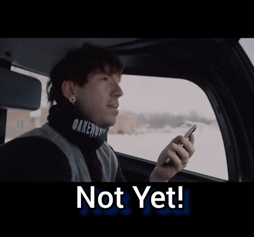 A Man Sitting In A Car Looking Out The Window With The Words Not Yet Below Him GIF