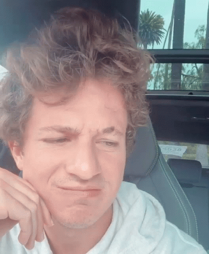 A Man Sitting In A Car Making A Funny Face With A License Plate That Says ' A ' On It GIF