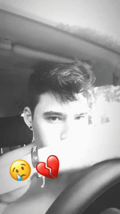 A Man Sitting In A Car With A Broken Heart And A Sad Face GIF