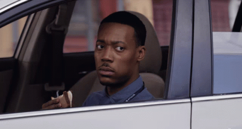 A Man Sitting In A Car With A Lanyard Around His Neck That Says Dispatcher On It GIF