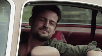 A Man Sitting In A Car With His Eyes Closed Smiling GIF