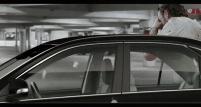 A Man Sitting In A Car With His Head In His Hand GIF