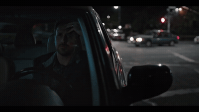 A Man Sitting In A Car With His Head In His Hand GIF