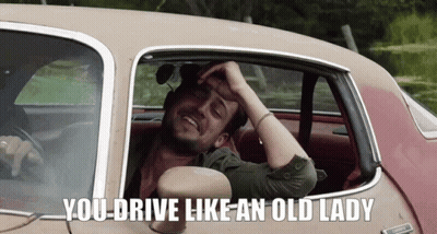 A Man Sitting In A Car With The Words " You Drive Like An Old Lady " Above Him GIF