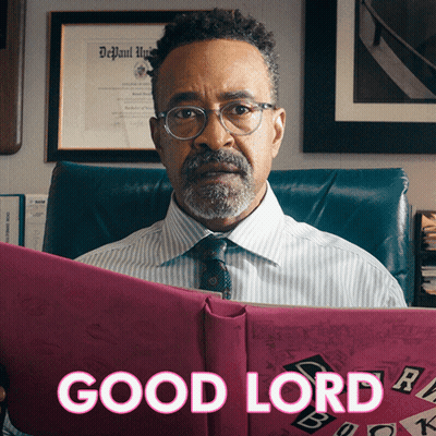 A Man Sitting In A Chair Holding A Book That Says Good Lord GIF