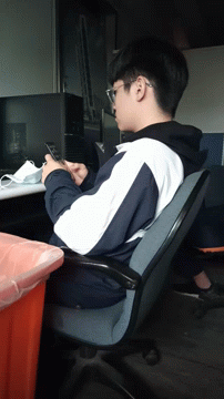 A Man Sitting In A Chair Looking At A Phone GIF