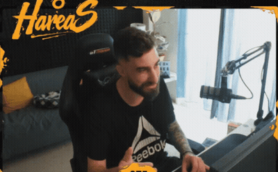 A Man Sitting In A Chair With A Reebok Shirt On GIF
