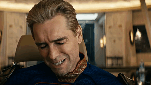 A Man Sitting In A Chair With His Eyes Closed And A Smile On His Face .. GIF