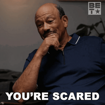 A Man Sitting In A Chair With His Hand On His Chin And The Words You 'Re Scared Below Him GIF
