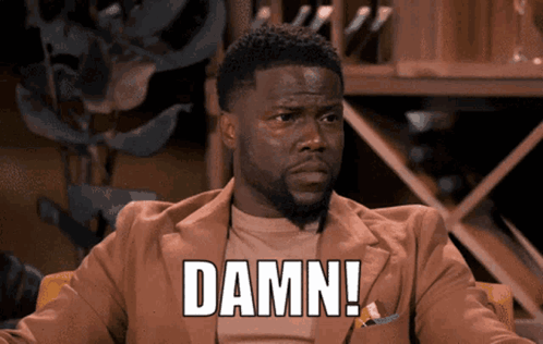 A Man Sitting In A Chair With The Word Damn Written On His Chest GIF