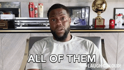 A Man Sitting In A Chair With The Words " All Of Them " On His Shirt GIF