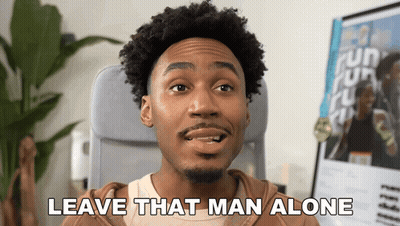 A Man Sitting In A Chair With The Words Leave That Man Alone Above Him GIF