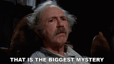 A Man Sitting In A Chair With The Words That Is The Biggest Mystery Above Him GIF