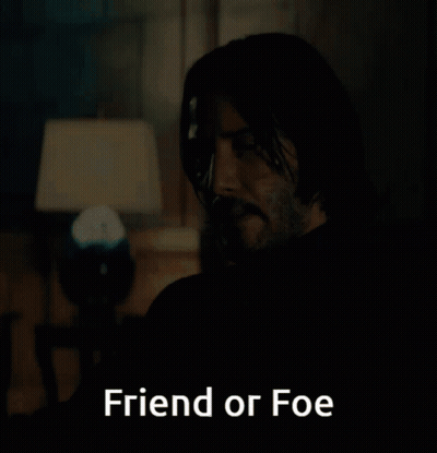 A Man Sitting In A Dark Room With The Words Friend Or Foe Above Him GIF