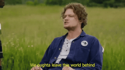 A Man Sitting In A Field With The Words We Oughta Leave This World Behind Below Him GIF