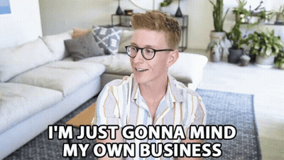 A Man Sitting In A Living Room With The Words I 'M Just Gonna Mind My Own Business GIF