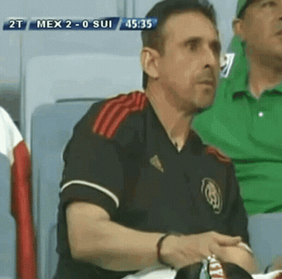 A Man Sitting In A Stadium Watching A Soccer Game Between Mexico And Sui GIF