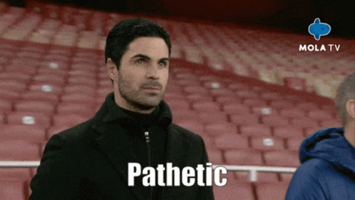 A Man Sitting In A Stadium With The Word Pathetic On The Screen GIF