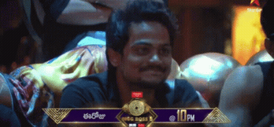 A Man Sitting In Front Of A Banner That Says Big Boss 5 At 10 Pm GIF