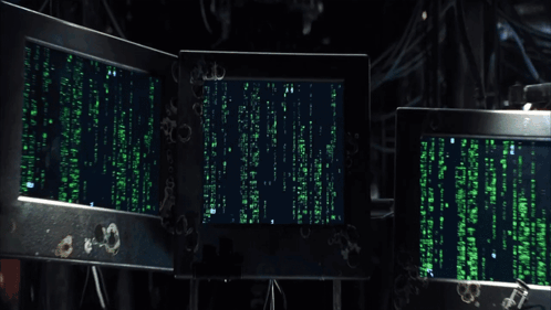 A Man Sitting In Front Of A Computer Screen That Says " Matrix " On It GIF