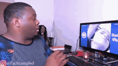 A Man Sitting In Front Of A Computer With A Picture Of A Woman On The Screen .. GIF