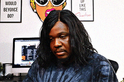 A Man Sitting In Front Of A Computer With A Sign On The Wall That Says Would Beyonce Do ? GIF