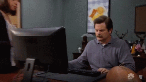 A Man Sitting In Front Of A Computer With Nbc Written On The Bottom GIF
