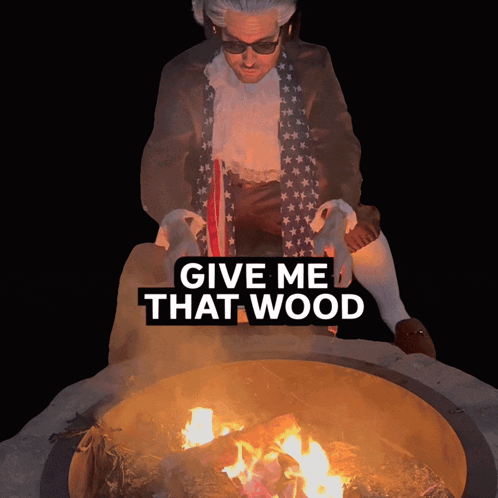 A Man Sitting In Front Of A Fire Pit With The Words Give Me That Wood Above Him GIF
