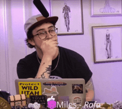 A Man Sitting In Front Of A Laptop With A Sticker That Says Protect Wild Utah On It GIF