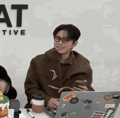 A Man Sitting In Front Of A Laptop With Stickers On It Including One That Says Join GIF
