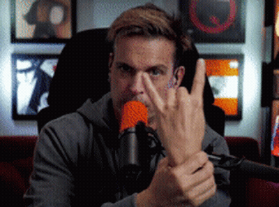 A Man Sitting In Front Of A Microphone Making A Middle Finger Gesture GIF